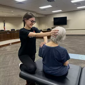 Madeleine doing a lateral neck stretch on a participant at a pop-up event in Waco.
