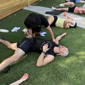 Rudy performing a stretch for the lumbar spine at a pop-up event with F45.