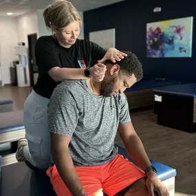 Madeline doing a lateral neck stretch on Jamie to loosen up some shoulder tension he was experiencing.