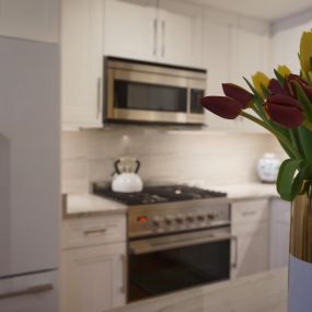 Kitchen with white cabinetry and a gold vase with yellow and purple tulips