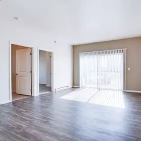 a large living room with large windows and two open doors to other rooms