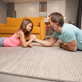 Dad and daughter on an area rug