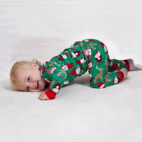 Baby boy in Christmas pajamas laying on clean carpet in Canon City