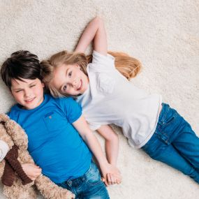 Boy and girl lying on clean carpets