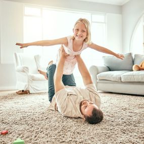 family enjoying a clean living room after professional carpet cleaning in Pueblo, CO