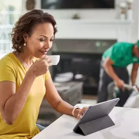 chem-dry technician performing an upholstery cleaning while a woman works from home