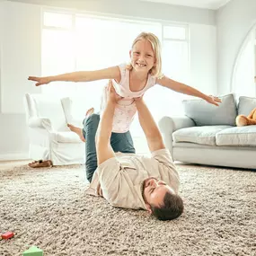 family enjoying a clean living room after professional carpet cleaning in Pueblo, CO