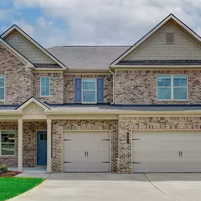 Two story  single family home with tan brick and 3-car garage in DRB Homes North Hampton community