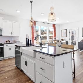 Kitchen with stainless steel appliances with island at DRB Homes The Grange community