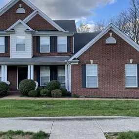 Brown brick home with asphalt shingle roof