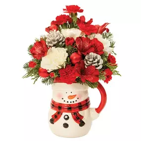 Keep the hot chocolate, and the love, flowing with this innovative holiday creation ideal for giving and for accenting seasonal décor. Carnations, alstroemeria and Christmas greens are beautifully arranged in a snowman pitcher with red ornaments and white-tipped pine cones.