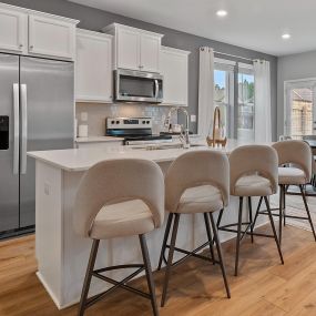Gourmet kitchen with white cabinets and island at DRB Homes The Borough at Wyndham South