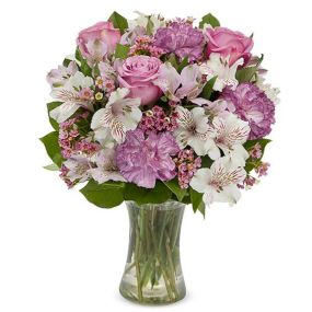 Have you ever seen two colors complement each other so perfectly? Lavender and white are the graceful focal points of this artistic arrangement featuring an exquisite mix of alstroemeria, roses, carnations, and waxflower in a clear gathering vase.