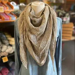 This triangular simple shawl is knit in one piece, starting with a garter tab cast on.
It's only stockinette stitch (that's knit a row, purl a row) with increases at the start of each row and in the center. 

We change yarns with simple wide color blocks.