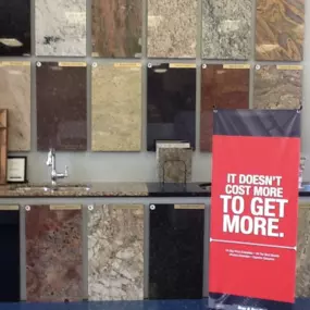 Kitchen countertop display with multiple countertop materials lined up and a red banner