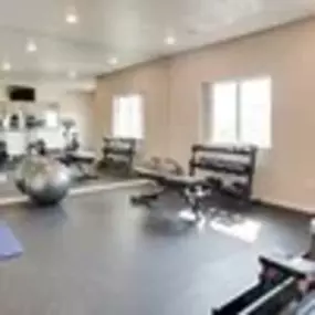 the spacious fitness center with weights and other exercise equipment