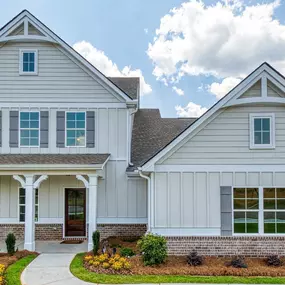 Two story single family home with white siding and brick in DRB Homes Kingston Community