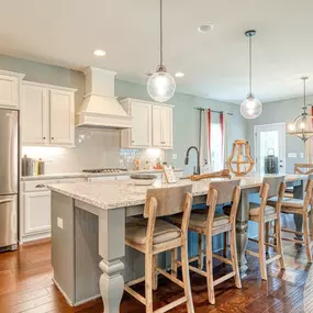 Gourmet kitchen with island and white cabinets in DRB Homes Kingston Community