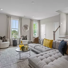 Family room with large tan sectional at DRB Homes Townes of Cotswold