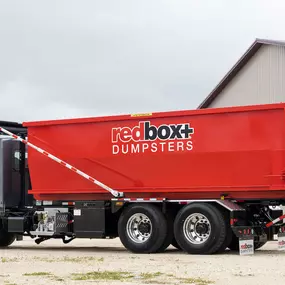 A dumpster rental is being delivered to a nearby construction project.