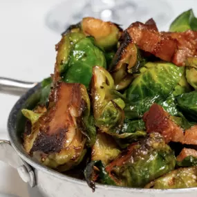 Brussels Sprouts are tossed with sea salt and crispy bacon lardons
