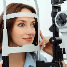 Woman receiving an eye exam through a slit lamp