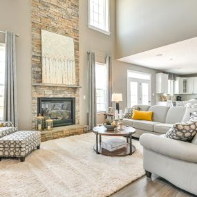 Family room with cathedral ceiling, fireplace and sitting area open to kitchen at DRB Homes Worthington Village at Charles Pointe