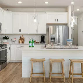 Kitchen with white cabinets, stainless steel appliances and island in a DRB Homes Boykins Run community.