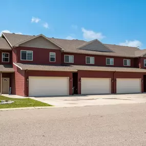 a house with two garage doors and a sign in front of it at Prairie Crossing Townhomes, Minnesota, 56529