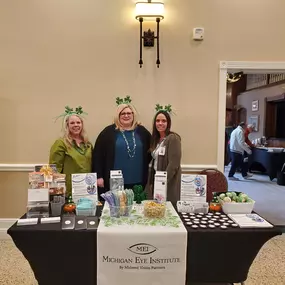 Michigan Eye Institute Employees Standing Behind a Booth