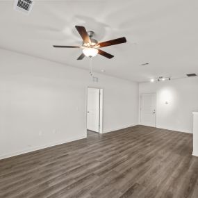 Unfurnished living room with fan and wooden floor