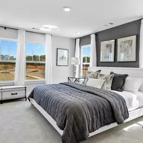 Spacious owners' suite with 5 windows and king size bed in the Litchfield Home Plan at DRB Hickory Heights community