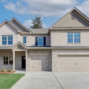 Tan brick two story home with 3 car garage in the DRB Homes Ridgewater community