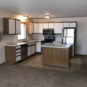 A kitchen with a sink, stove, and refrigerator.