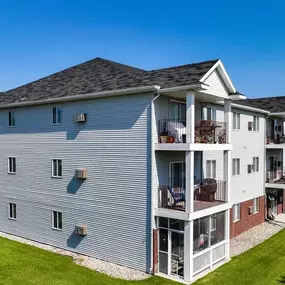 A row of townhouses with balconies and a clear blue sky above.