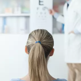 Optometrist giving patient an eye exam.