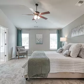 Owner's suite with vaulted ceiling, seating area and two windows in the DRB Homes Towne Center community