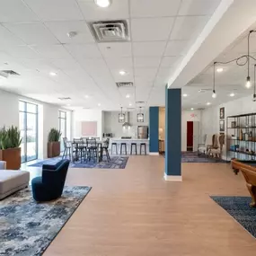 a large lobby with couches and chairs and a pool table