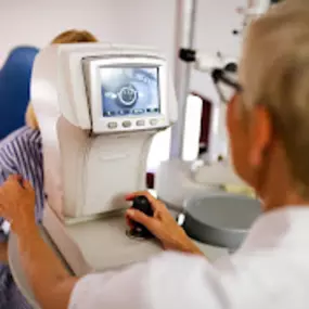 Optometrist scanning patients eyes for check up