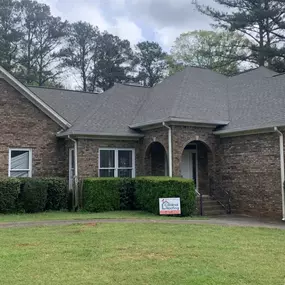 Brown brick home with black asphalt shingle roof