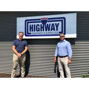 Team members: Vince and Ryan in front of Highway Equipment & Supply Co. logo