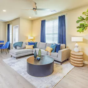 apartment living room with ceiling fan and large windows