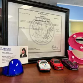 Sarvy Ranjbar's desk with vintage model car, business card and insurance license