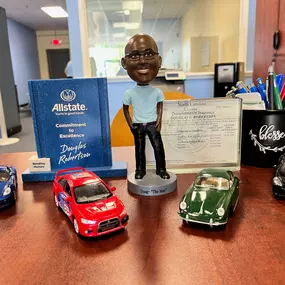 Desk with Doug Robertson's bobblehead and vintage model cars