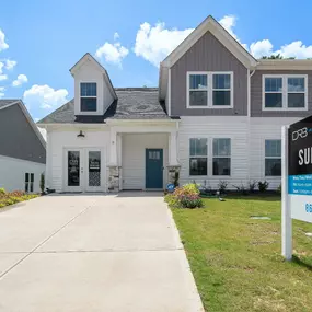 Two story single family home with white and gray siding. The Summit home plan at DRB Homes Camden Cottages