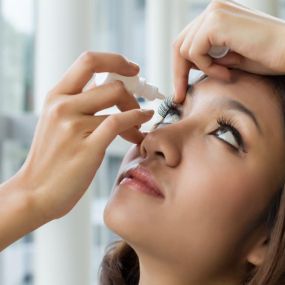 woman putting eye drops in eyes