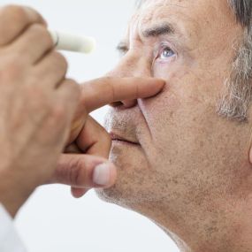 older man getting eyes checked out at eye doctor