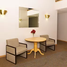 a room with a table and three chairs in front of a mirror