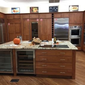 kitchen appliance showroom with wooden cabinetry, a kitchen island, and built in kitchen appliances