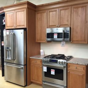 kitchen showroom with wooden cabinets and stainless steel kitchen appliances on display